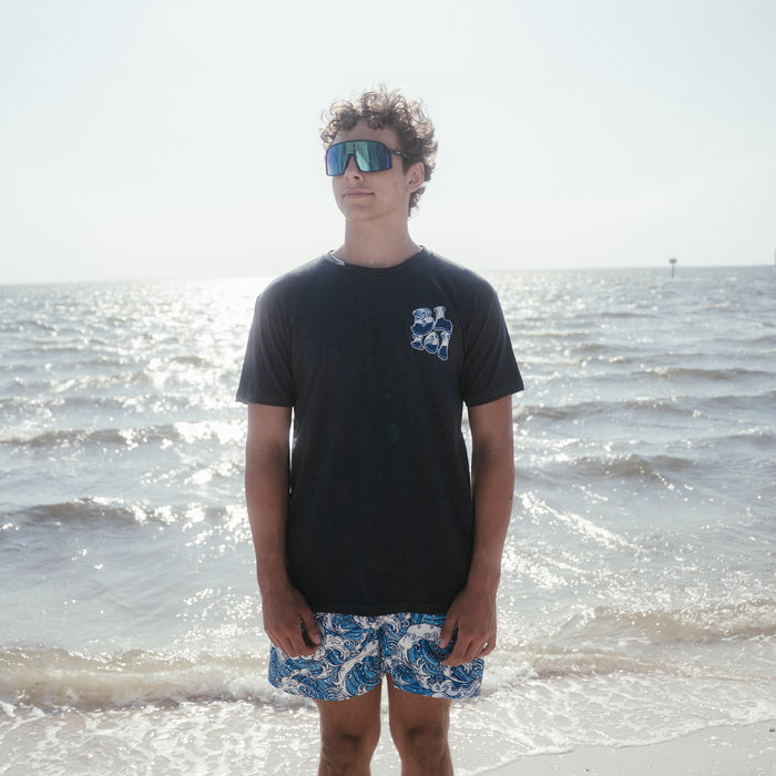 Youth model wearing navy Wave youth graphic tee