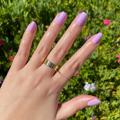 Hand showing You're Invited - Press-On | Short | Squoval with short squoval false nails in playful lilac purple manicure outdoors